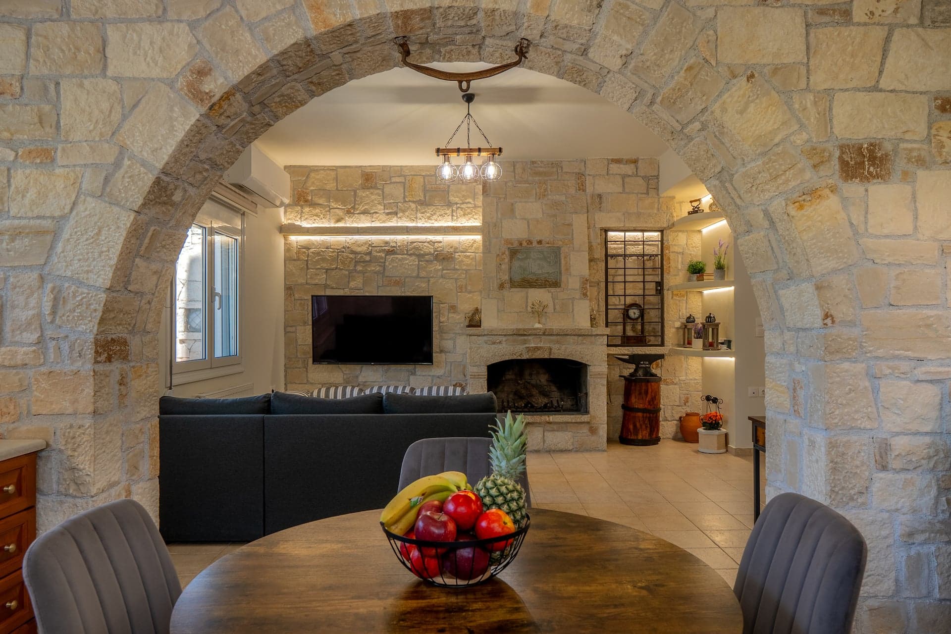 The stone-arched living room of Casa di Tzaki with its fireplace